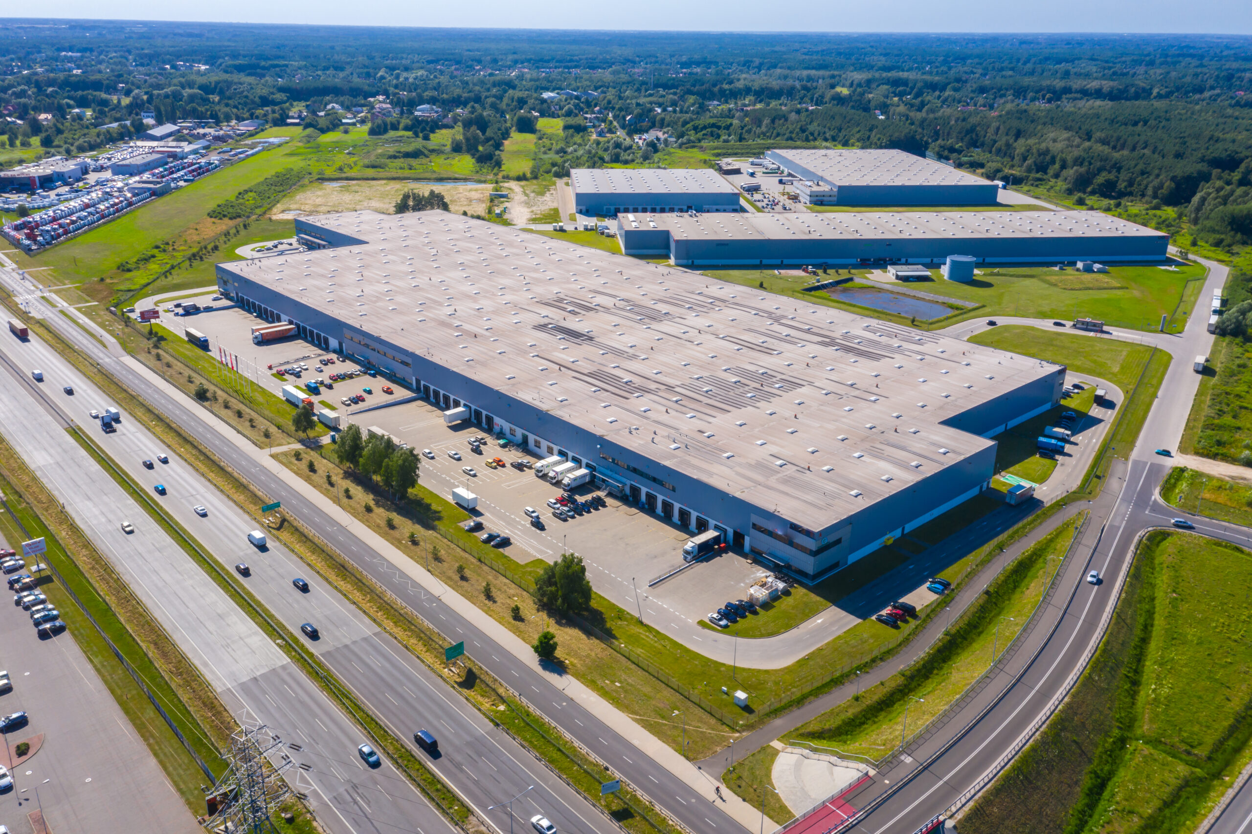 Aerial image of a large warehouse and logistics facility with loading bays and trailers, representing the distribution infrastructure that supports SME supply chains.